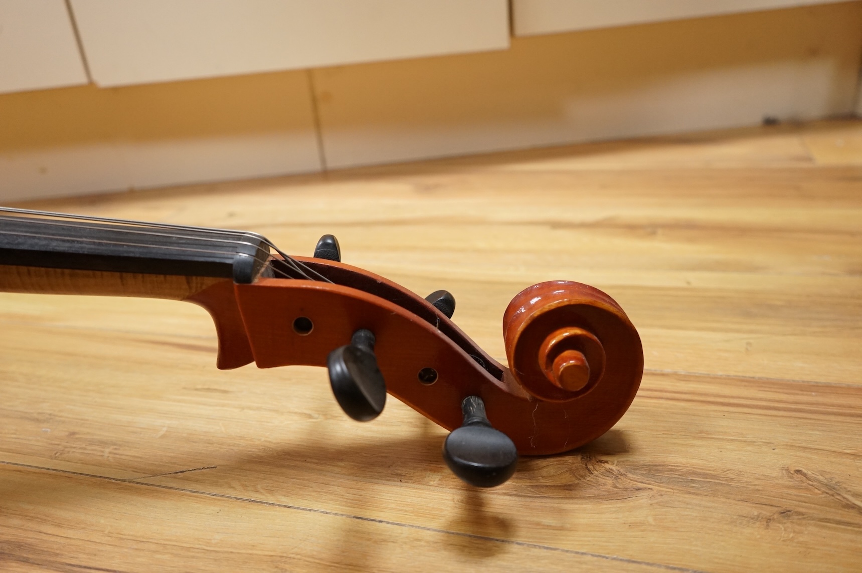 A modern student’s cello in a soft case and a student’s Spanish classical guitar